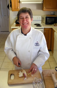 Sarah in a Utah Shakespeare Festival chef's jacket slicing apples in our kitchen