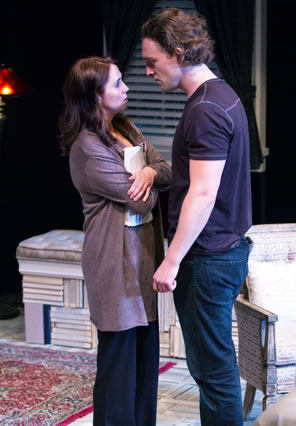 Olivia in long gray sweater and blue pants holds her manuscript tight to her breast with crossed arms as Ehtan in purple tee and blue jeans towers over her.